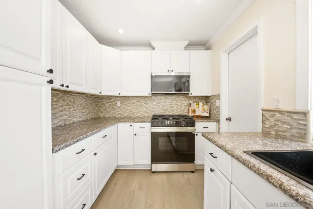 a kitchen with stainless steel appliances granite countertop a stove sink and cabinets