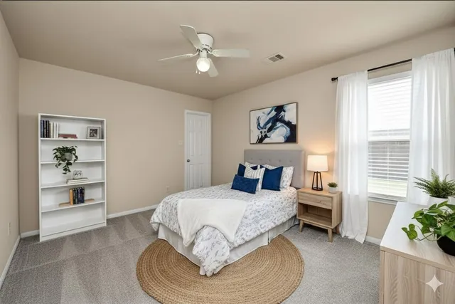 a bedroom with a large bed and a chandelier