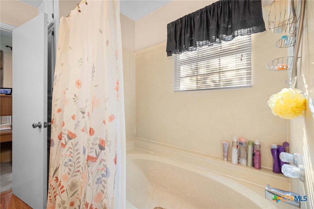 1213 North Main Street Temple, TX 76501 - Photo 14 of 37 a bathroom with a bathtub and shower curtain