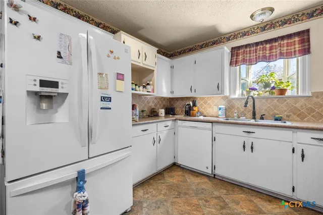 a kitchen that has a lot of cabinets in it and appliances