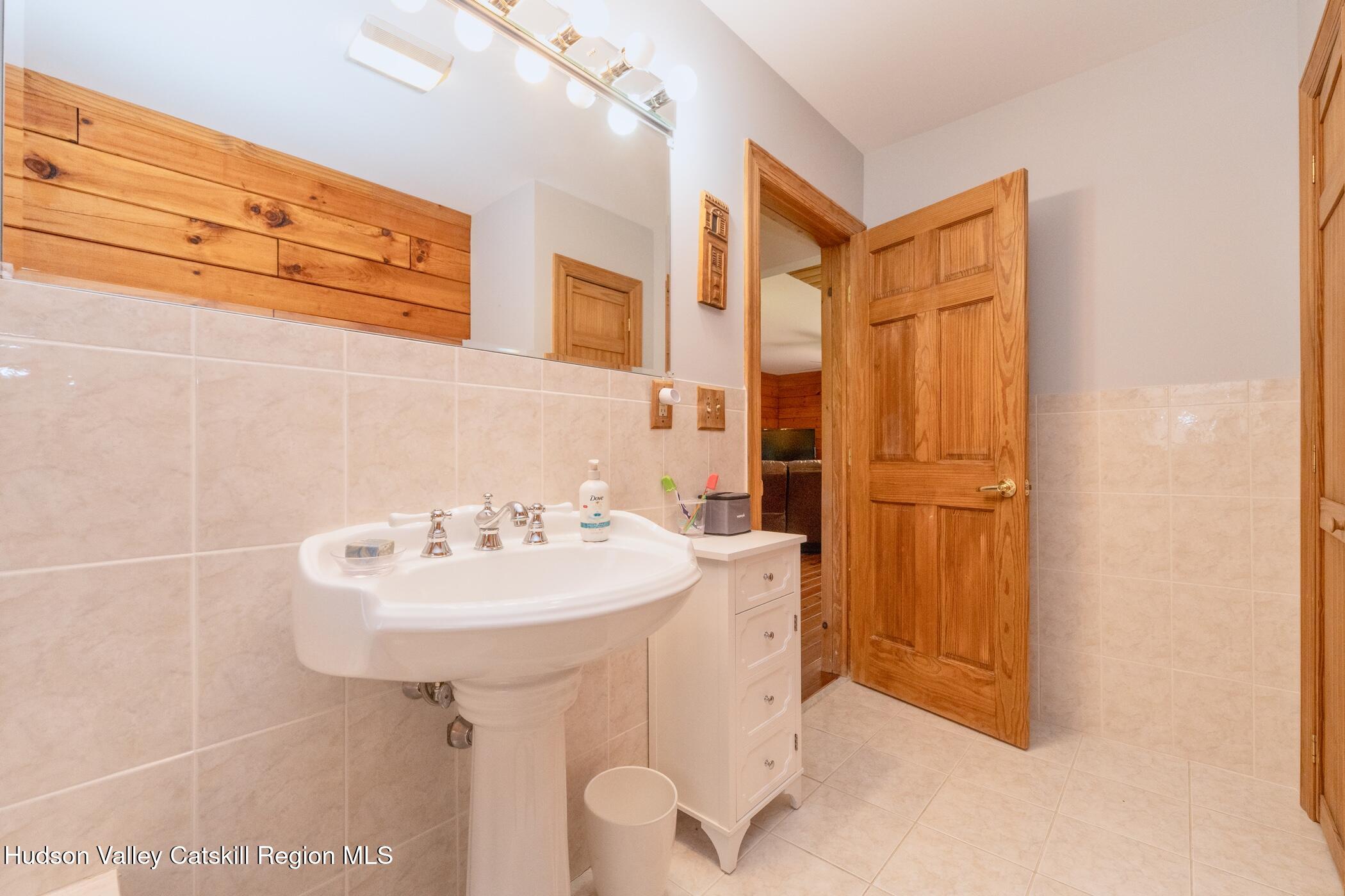 140 Stone Dock Road High Falls, NY 12440 - Photo 19 of 42 a bathroom with a sink a mirror and a shower
