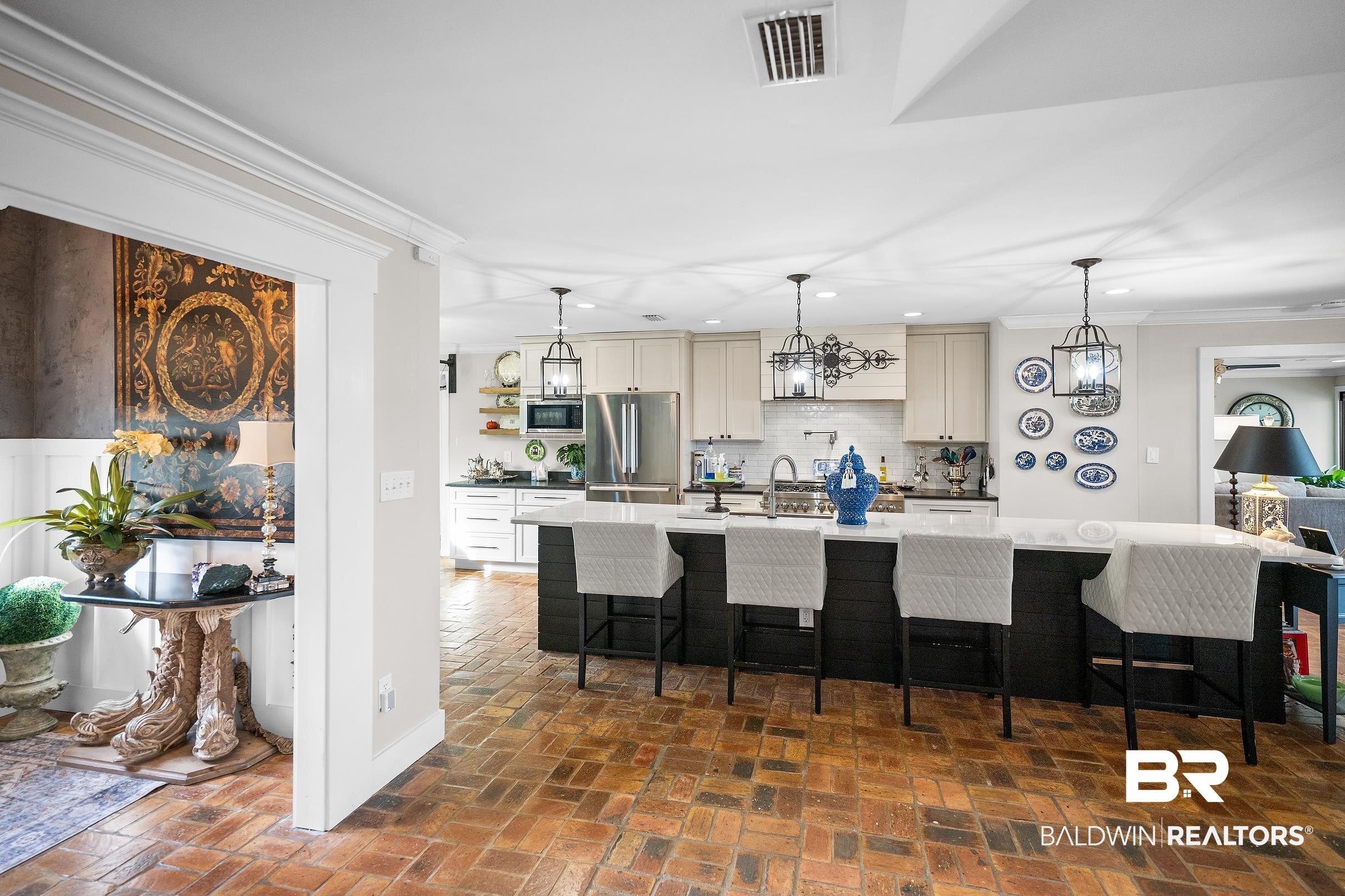 8490 Bay View Drive Foley, AL 36535 - Photo 24 of 67 Kitchen featuring crown molding, a kitchen breakfast bar, decorative light fixtures, brick flooring, and tasteful backsplash