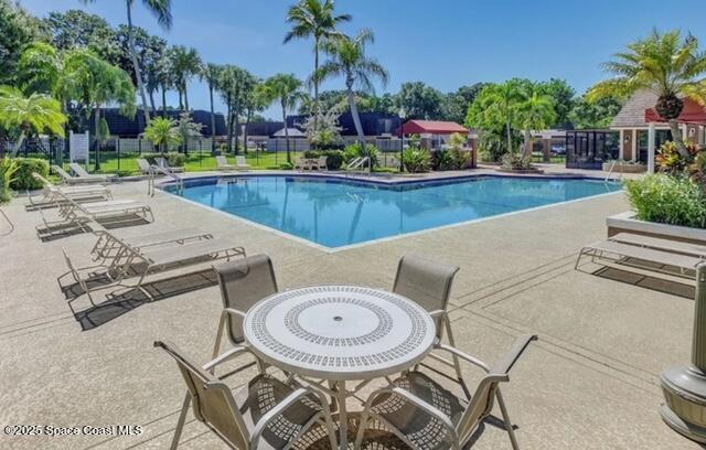 7002 70th Way, Unit 7002 West Palm Beach, FL 33407 - Photo 32 of 39 a view of a patio with swimming pool table and chairs