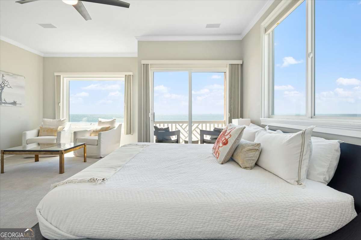1028 Beach View Drive, Unit 5 St. Simons, GA 31522 - Photo 1 of 44 a large white bed sitting in a bedroom next to a window