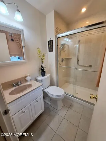 a bathroom with a granite countertop sink toilet a mirror and shower