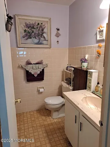 a bathroom with a toilet a sink and mirror