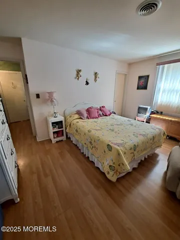 a bedroom with a bed and wooden floor
