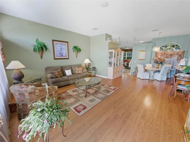 a living room with furniture a chandelier and a dining table