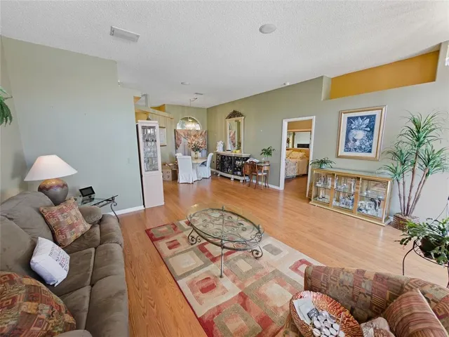 a kitchen with stainless steel appliances granite countertop a stove top oven a sink dishwasher and white cabinets with wooden floor