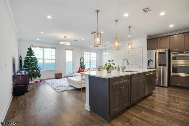 a large kitchen with kitchen island white cabinets and stainless steel appliances