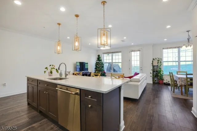a large kitchen with a counter space a sink appliances and living room view