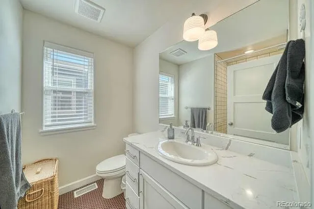 a bathroom with a sink a toilet and a mirror