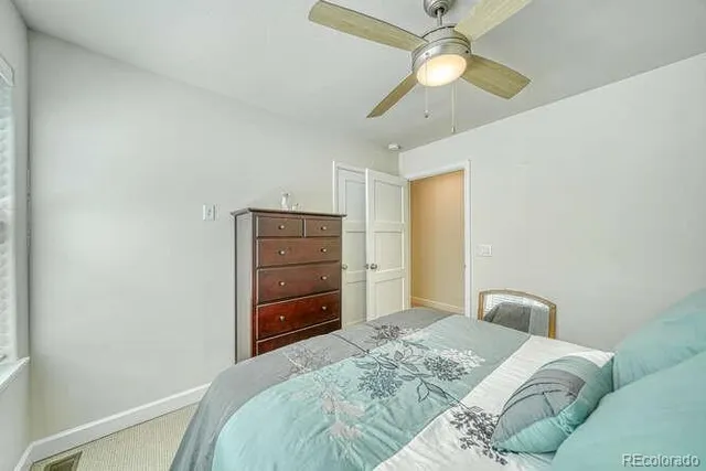 a bedroom with a bed and a ceiling fan
