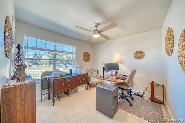 a view of a workspace with furniture and a window