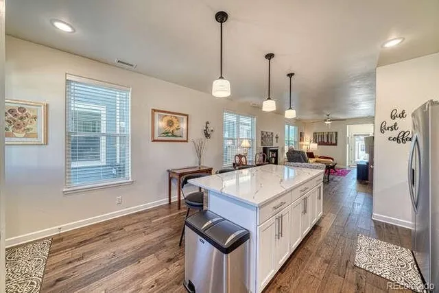 a kitchen that has a lot of cabinets and a wooden floor