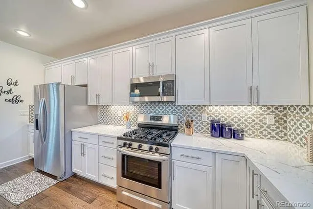 a kitchen with white cabinets and stainless steel appliances