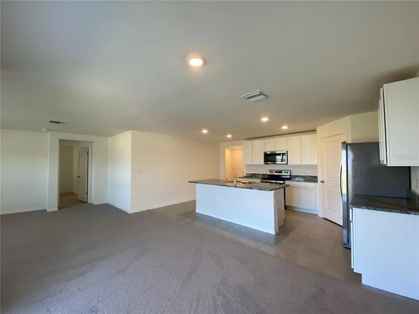 a kitchen with a refrigerator and a stove top oven
