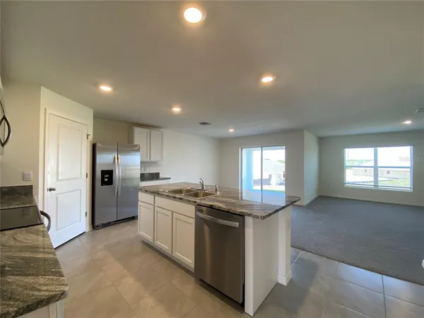 a kitchen with stainless steel appliances granite countertop a stove a sink and a refrigerator