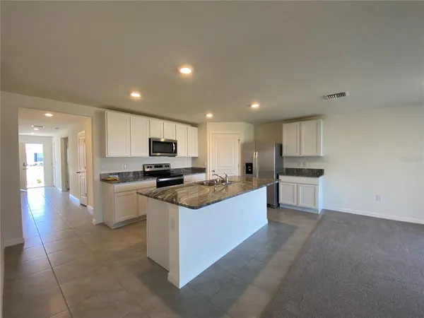 a kitchen with stainless steel appliances kitchen island sink stove and cabinets