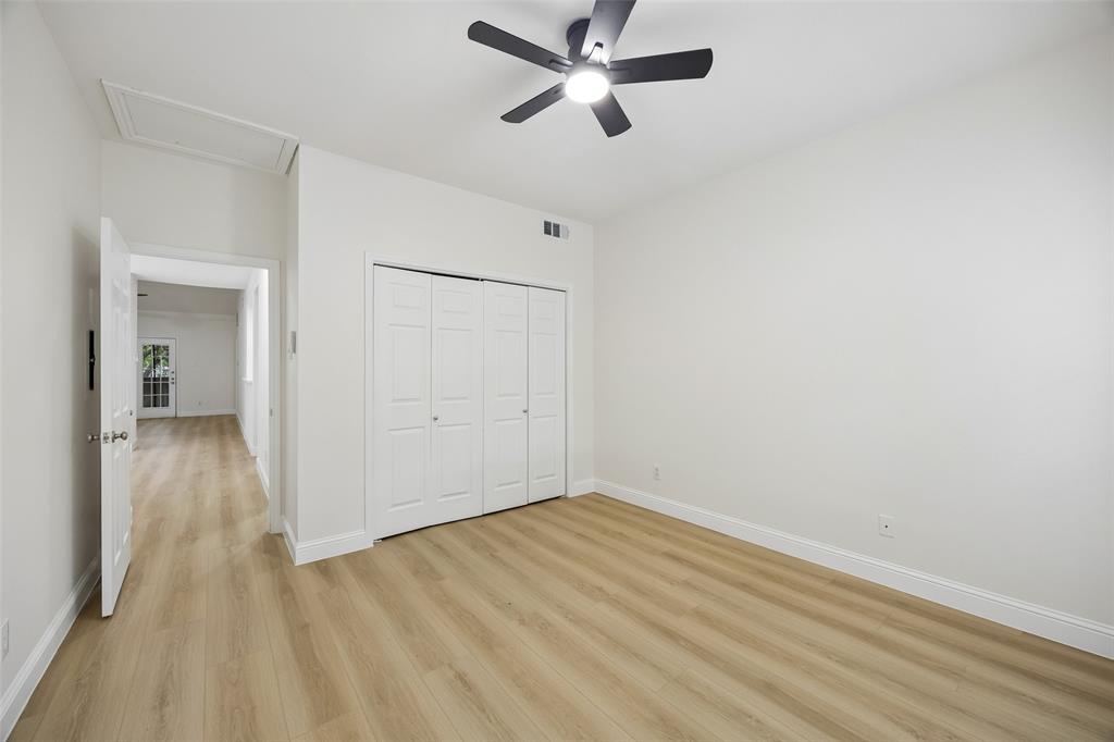 12660 Hillcrest Road, Unit 7205 Dallas, TX 75230 - Photo 17 of 25 Interior room featuring light wood-finish flooring, white walls, and a black ceiling fan with integrated lighting