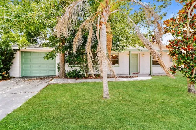 front view of house with a yard and trees
