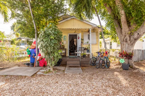a front view of a house with a tree