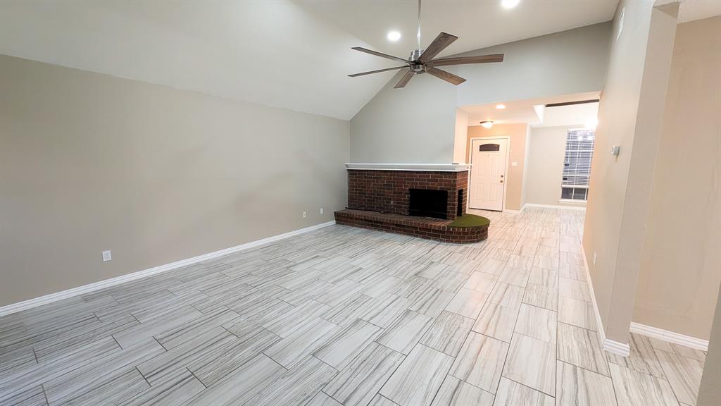 2129 Fawn Ridge Trail Carrollton, TX 75010 - Photo 14 of 30 an empty room with wooden floor fireplace and windows