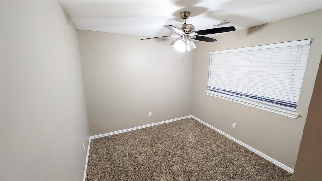 2129 Fawn Ridge Trail Carrollton, TX 75010 - Photo 21 of 30 an empty room with windows and fan