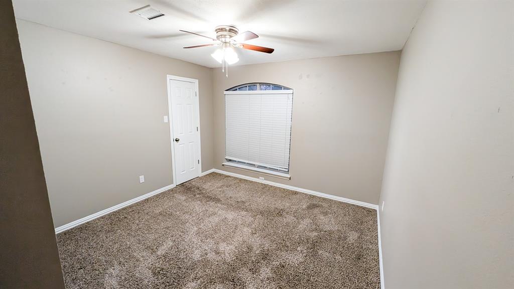 2129 Fawn Ridge Trail Carrollton, TX 75010 - Photo 24 of 30 an empty room with a chandelier fan and windows