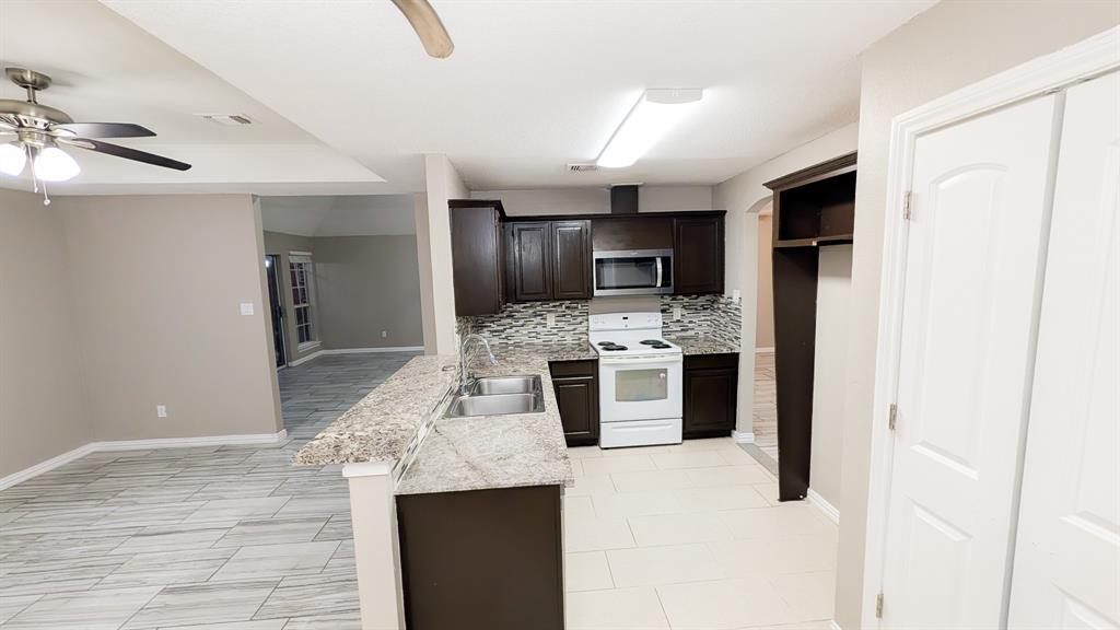 2129 Fawn Ridge Trail Carrollton, TX 75010 - Photo 26 of 30 a kitchen with stainless steel appliances kitchen island granite countertop a refrigerator a stove and oven