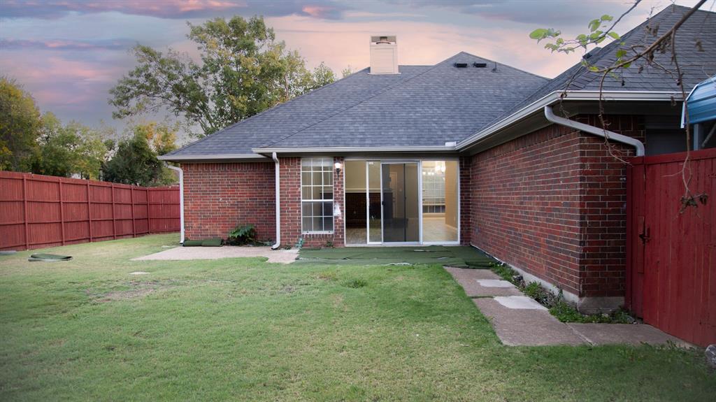 2129 Fawn Ridge Trail Carrollton, TX 75010 - Photo 29 of 30 a view of a backyard with plants and brick wall