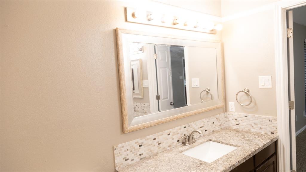 2129 Fawn Ridge Trail Carrollton, TX 75010 - Photo 3 of 30 a bathroom with a granite countertop sink and a mirror