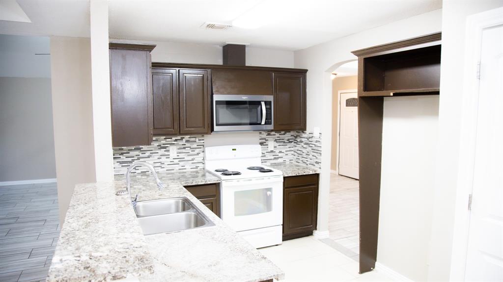 2129 Fawn Ridge Trail Carrollton, TX 75010 - Photo 7 of 30 a kitchen with stainless steel appliances kitchen island granite countertop a refrigerator and a stove top oven