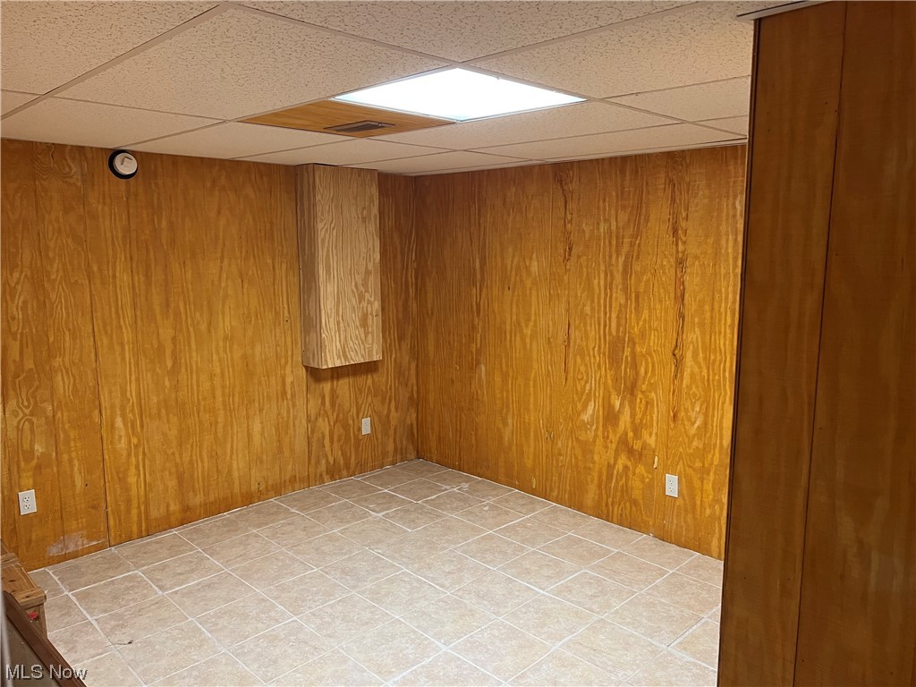 6950 Walker Road Walker, WV 26180 - Photo 16 of 22 Basement Unfurnished room with a paneled ceiling and wooden walls Could be 4th bedroom