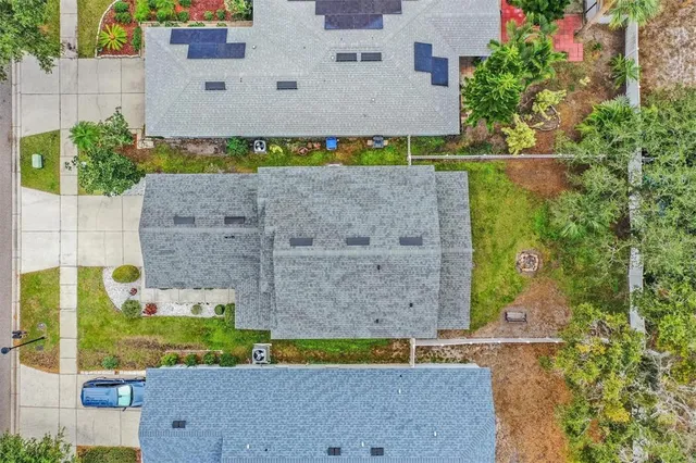 an aerial view of a house with a yard and large tree