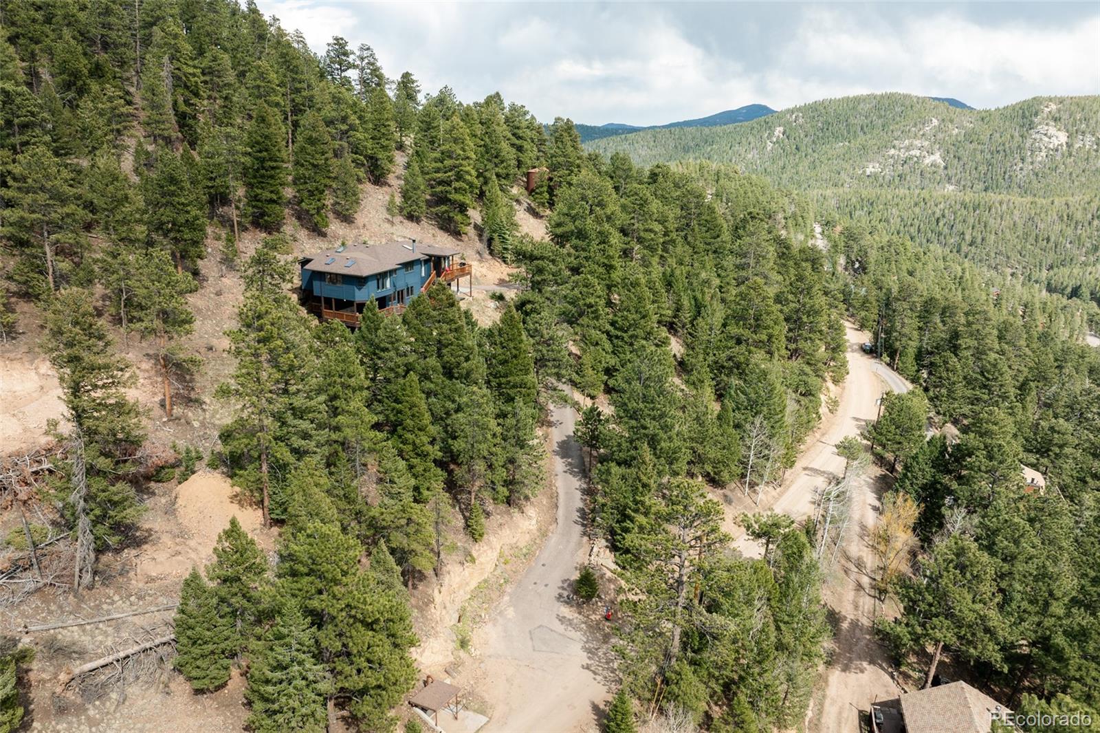 7290 Timber Trail Road Evergreen, CO 80439 - Photo 4 of 11 a view of a mountain from a forest