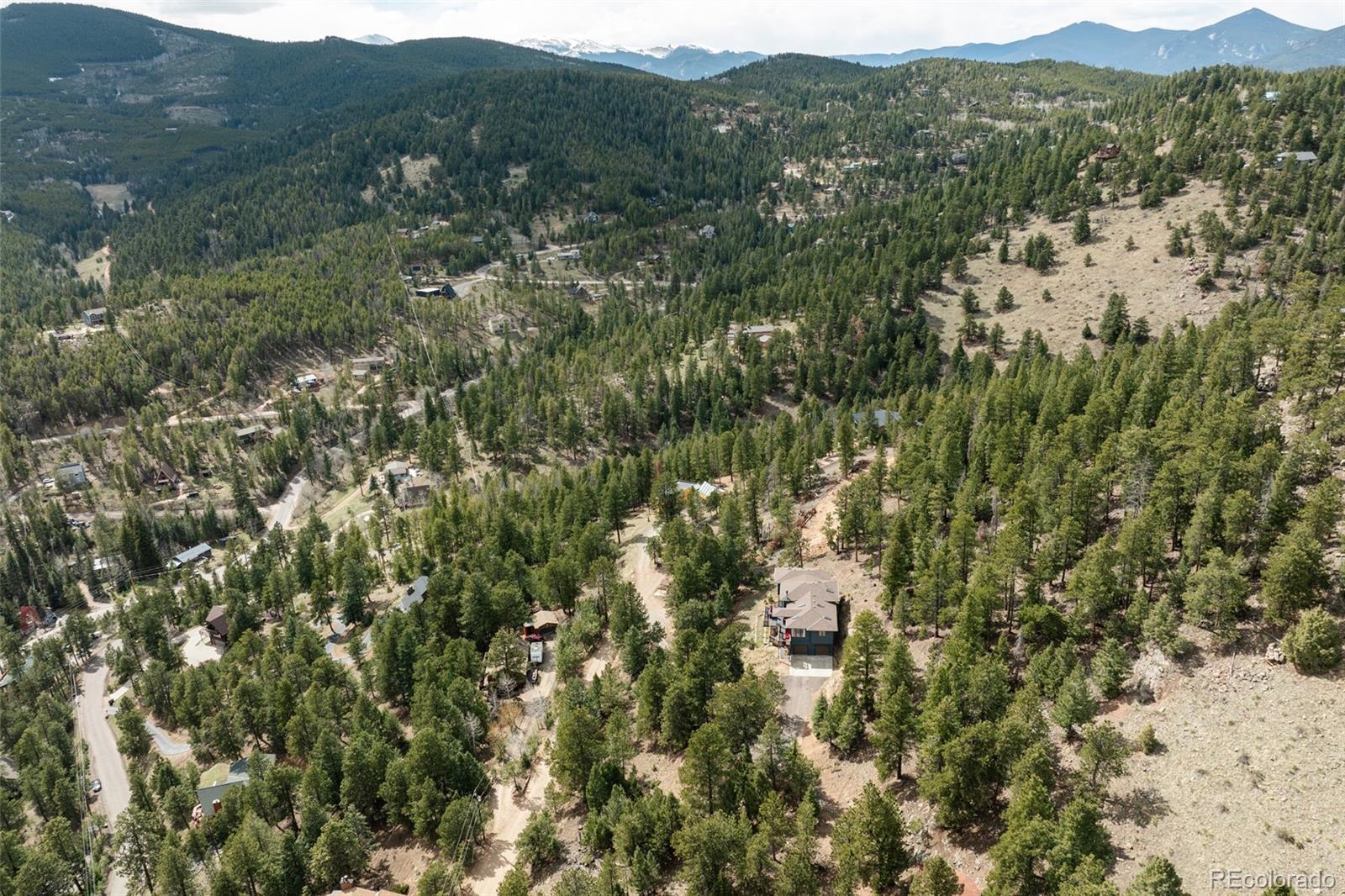 7290 Timber Trail Road Evergreen, CO 80439 - Photo 9 of 11 a view of a mountain range with lush green forest