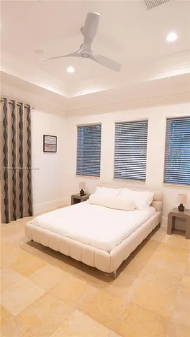 a living room with a bed furniture and chandelier