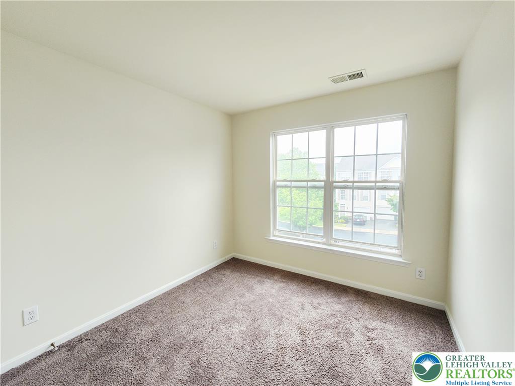 8513 Gateway Road Breinigsville, PA 18031 - Photo 38 of 45 A well-lit bedroom features plush carpeting and a double window with neighborhood views.