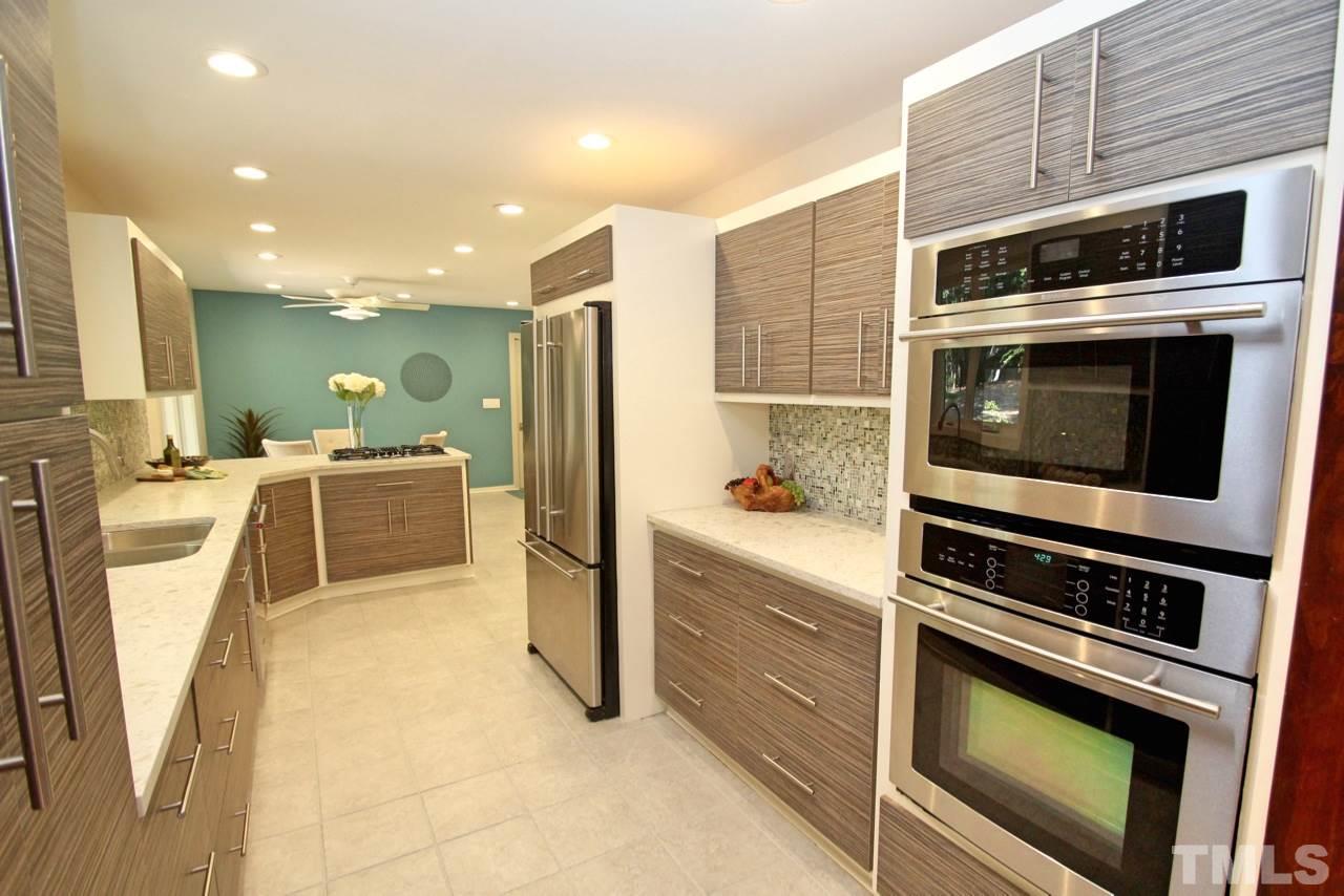 122 Queensferry Road Cary, NC 27511 - Photo 4 of 25 a kitchen with stainless steel appliances a stove a microwave and a refrigerator