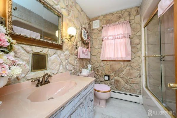a bathroom with a sink toilet vanity and shower