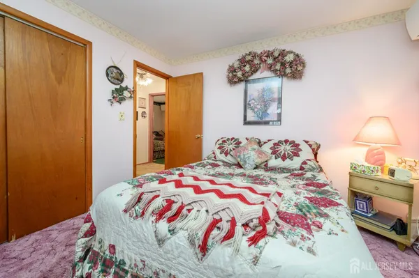 a bedroom with a bed and a lamp on dresser