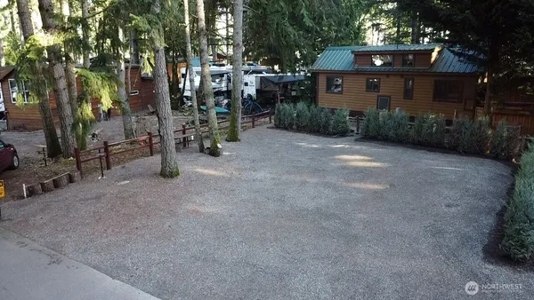 a view of a house with a yard and large trees