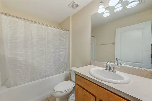 a bathroom with a sink a toilet and shower curtain