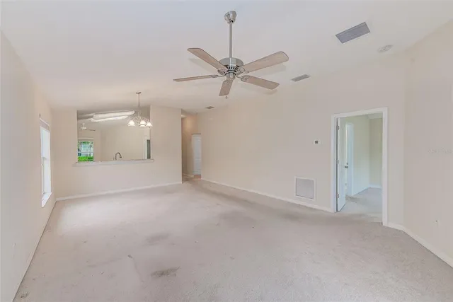 a view of a big room with a chandelier fan and windows