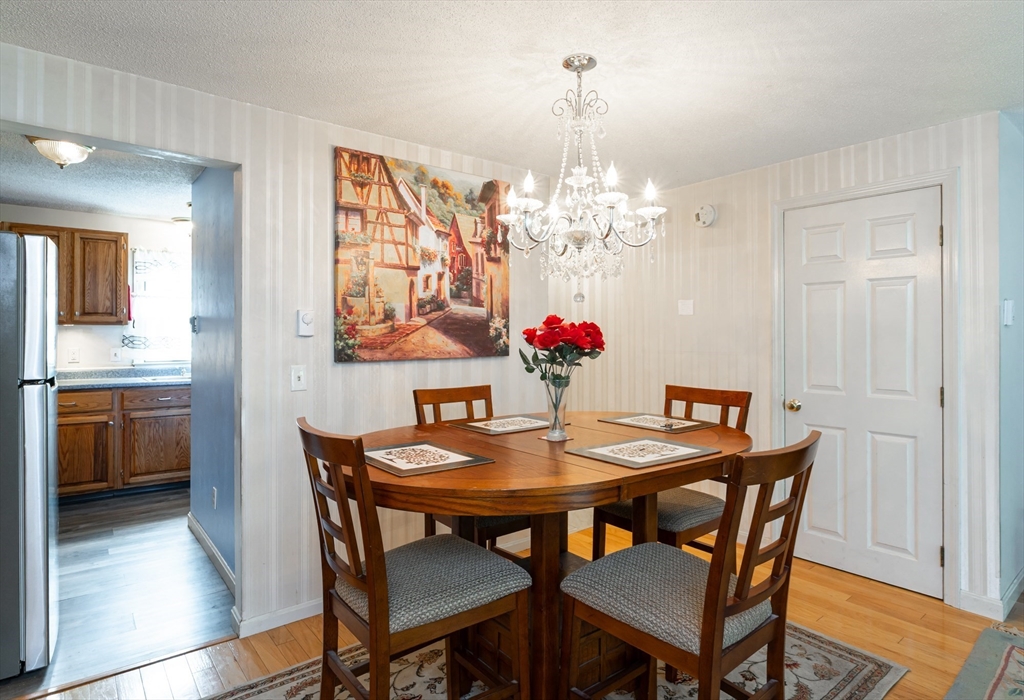 56 Durham Road, Unit 40 Dover, NH 03820 - Photo 8 of 42 a view of a dining room with furniture wooden floor and chandelier
