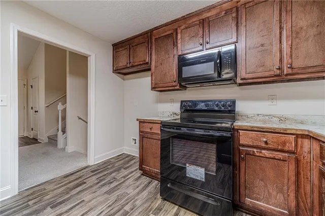 a kitchen with stainless steel appliances granite countertop a stove microwave and refrigerator