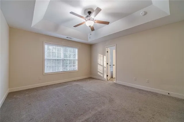 an empty room with windows and ceiling fan