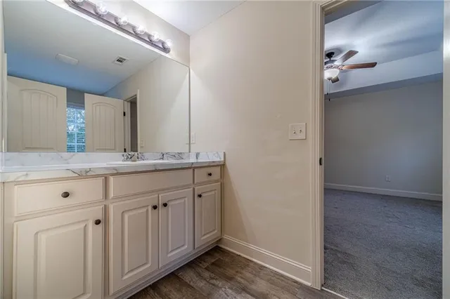 a bathroom with a granite countertop sink and a mirror