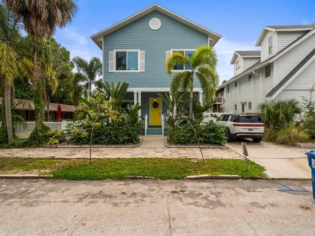 a front view of a house with a garden and plants